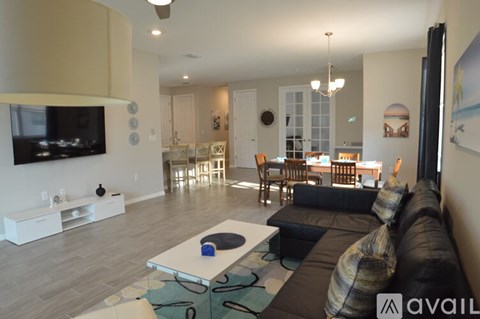 A living room with a black couch and a television.