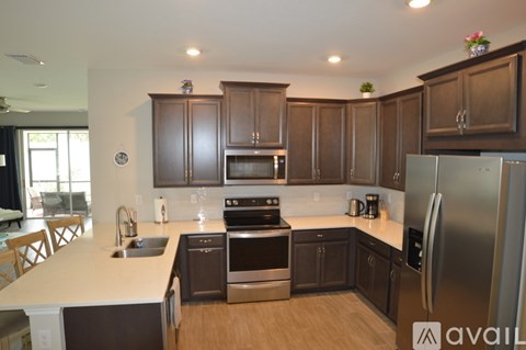 A kitchen with dark brown cabinets and stainless steel appliances.
