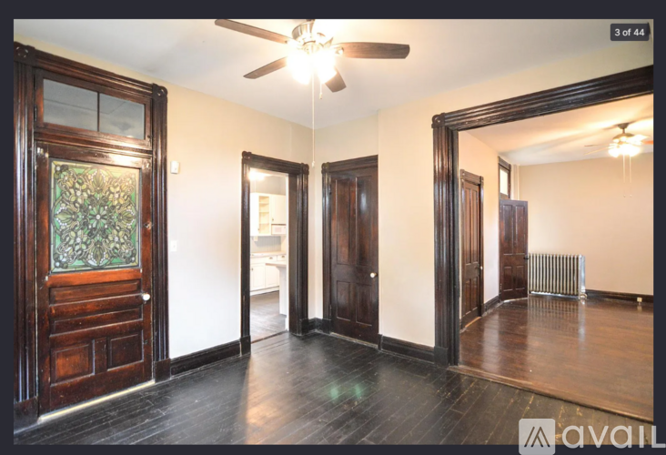 A room with a wooden floor and a ceiling fan.