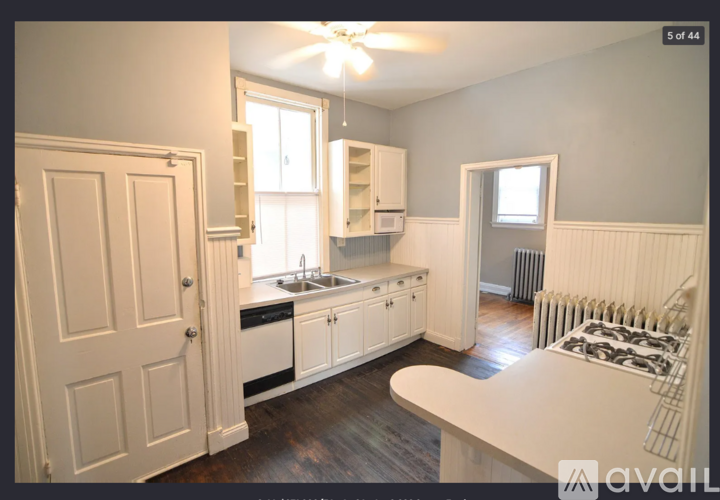 A kitchen with white cabinets and a white countertop.