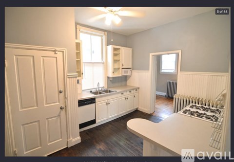 A kitchen with white cabinets and a white countertop.