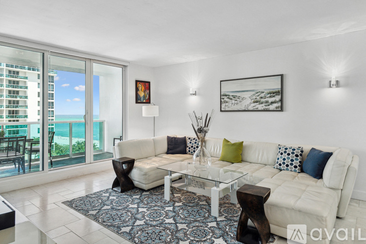 A living room with a white couch and a glass table.