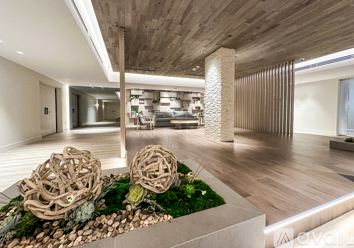 A modern interior space with a wooden ceiling and a stone pillar.