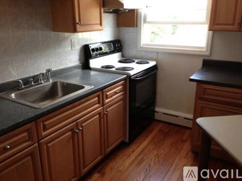A kitchen with wooden cabinets and black countertops.