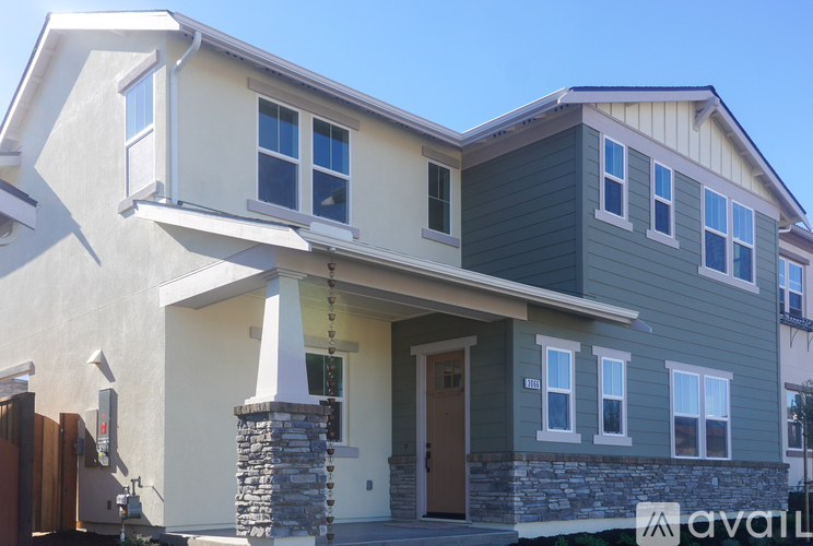 A modern two-story house with a stone pillar in front.