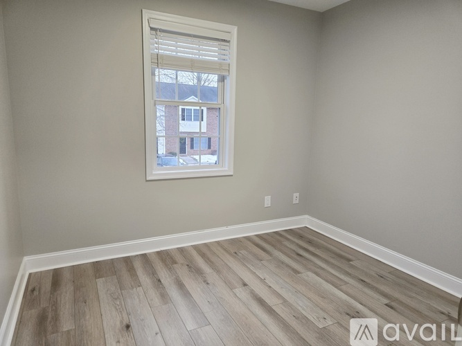 A room with a window showing a view of a building outside.