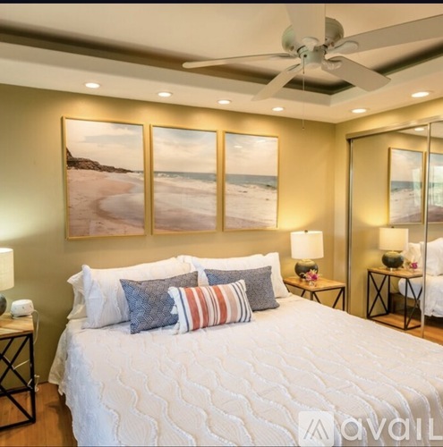 A bedroom with a large bed and a ceiling fan.
