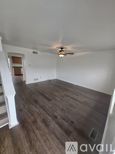 A room with wooden flooring and a ceiling fan.