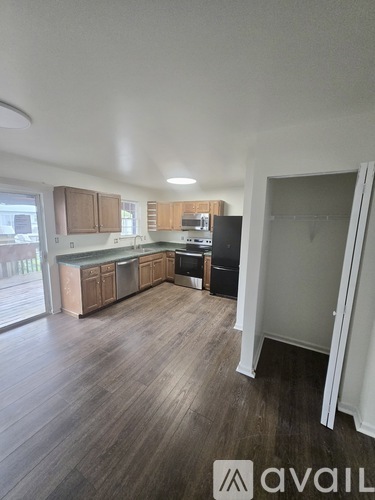 A kitchen with wooden floors and a white ceiling.