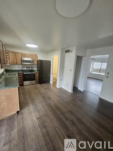 A kitchen with wooden cabinets and a black refrigerator.