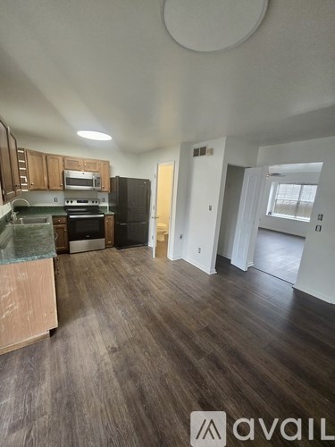 A kitchen with wooden cabinets and a black refrigerator.