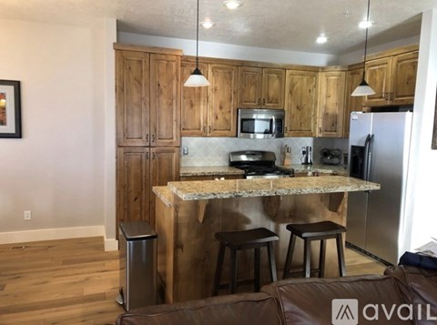 A kitchen with wooden cabinets and a granite countertop.