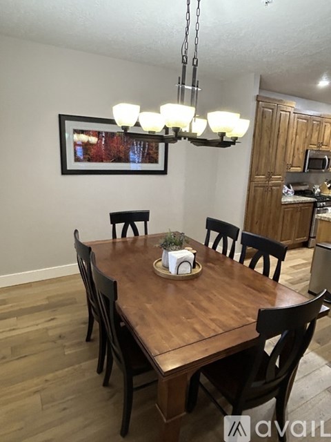 A dining room with a wooden table and chairs.