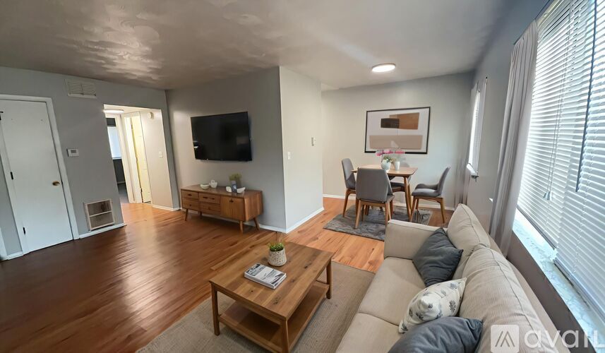 A living room with a wooden floor and a grey sofa.