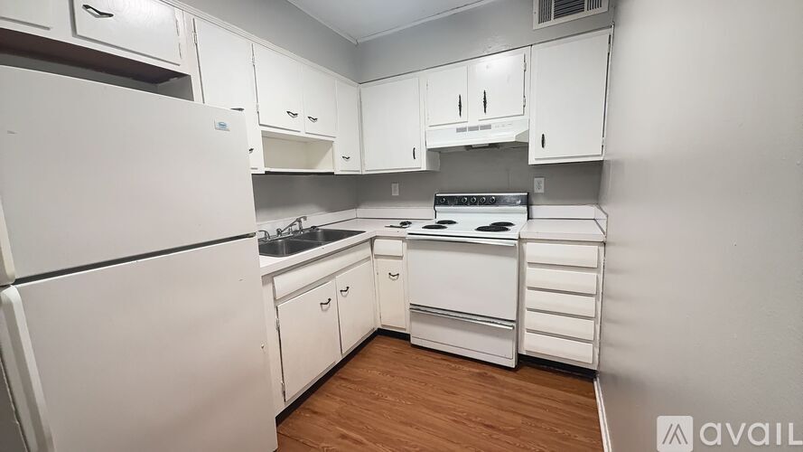 A kitchen with white appliances and cabinets.
