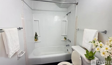 A white bathroom with a tub, toilet, and sink.