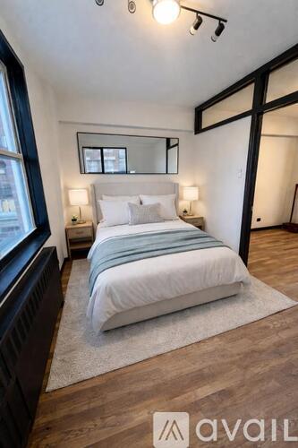 A bedroom with a large bed and a mirror above it.