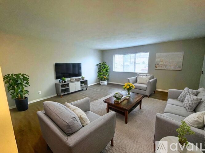 A living room with a grey couch, a coffee table, and a television.