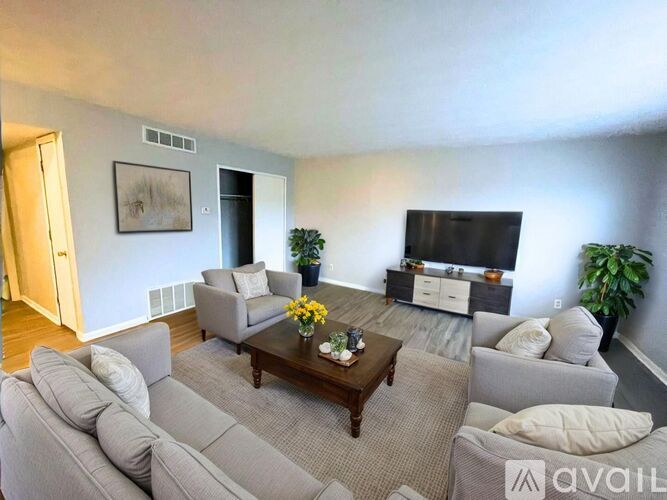 A living room with a grey couch, a coffee table, and a flat screen TV.