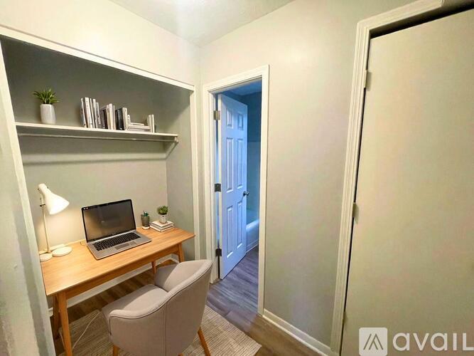 A small room with a desk, chair, and a laptop.