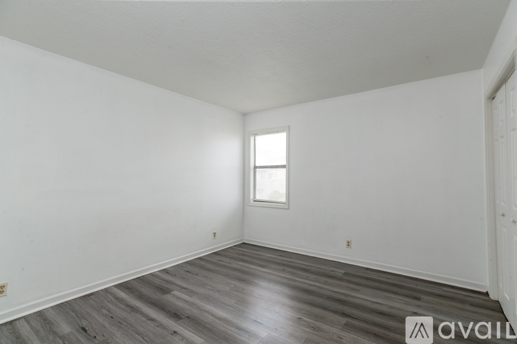 A room with a window and wooden flooring is available for rent.