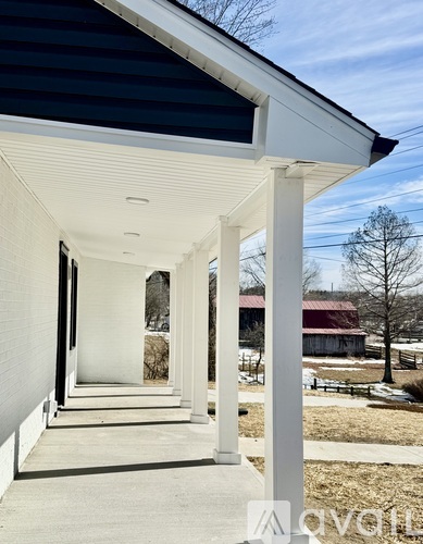 A white house with a porch and pillars.