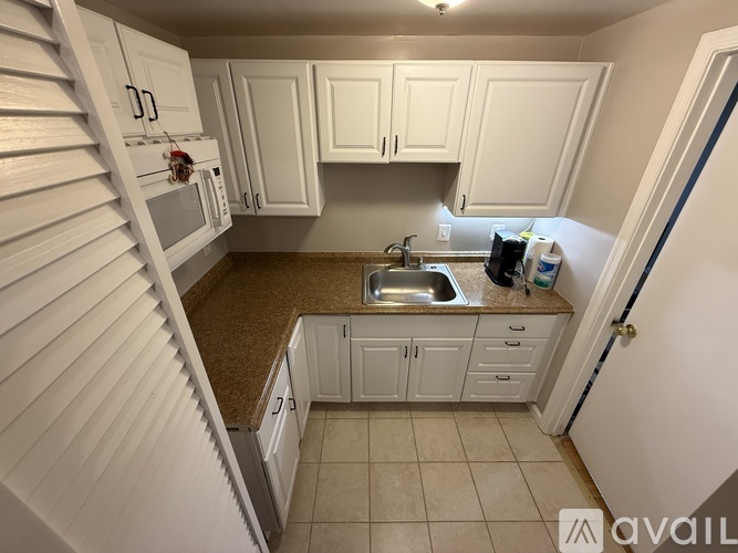 A kitchen with white cabinets and a granite countertop.