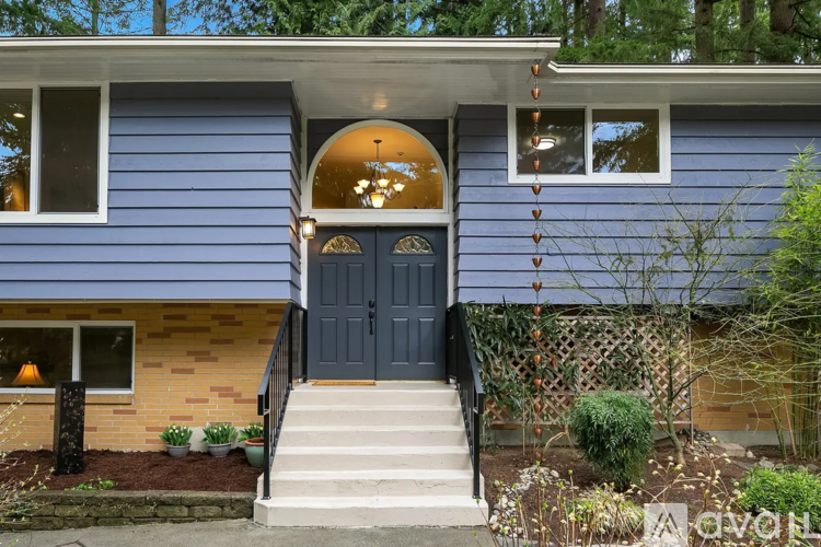 A blue house with a black front door and a small porch.