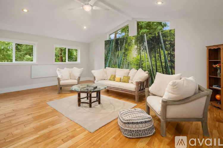 A living room with a glass table and white couches.