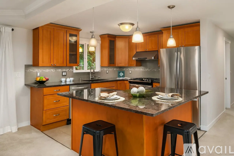 A kitchen with wooden cabinets and a granite countertop.