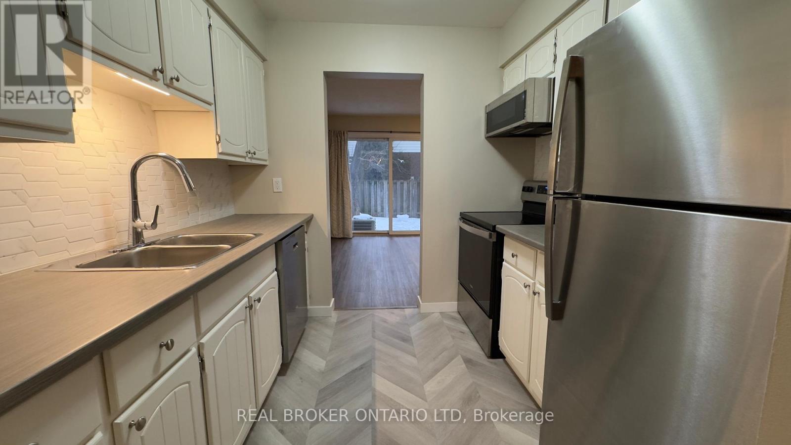 A kitchen with a sink, stove, and refrigerator.