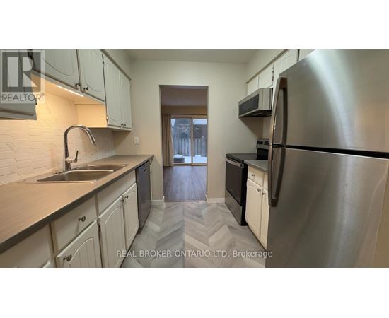 A kitchen with a sink, stove, and refrigerator.