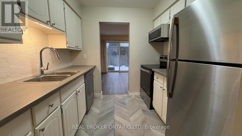 A kitchen with a sink, stove, and refrigerator.