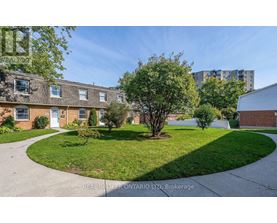 A real estate company's photo of a residential area with houses and a grassy area.