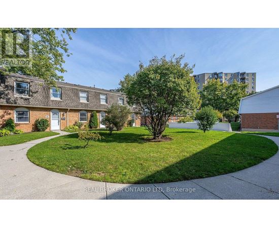 A real estate company's photo of a residential area with houses and a grassy area.