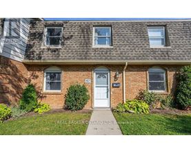 A house with a white door and windows is for sale.