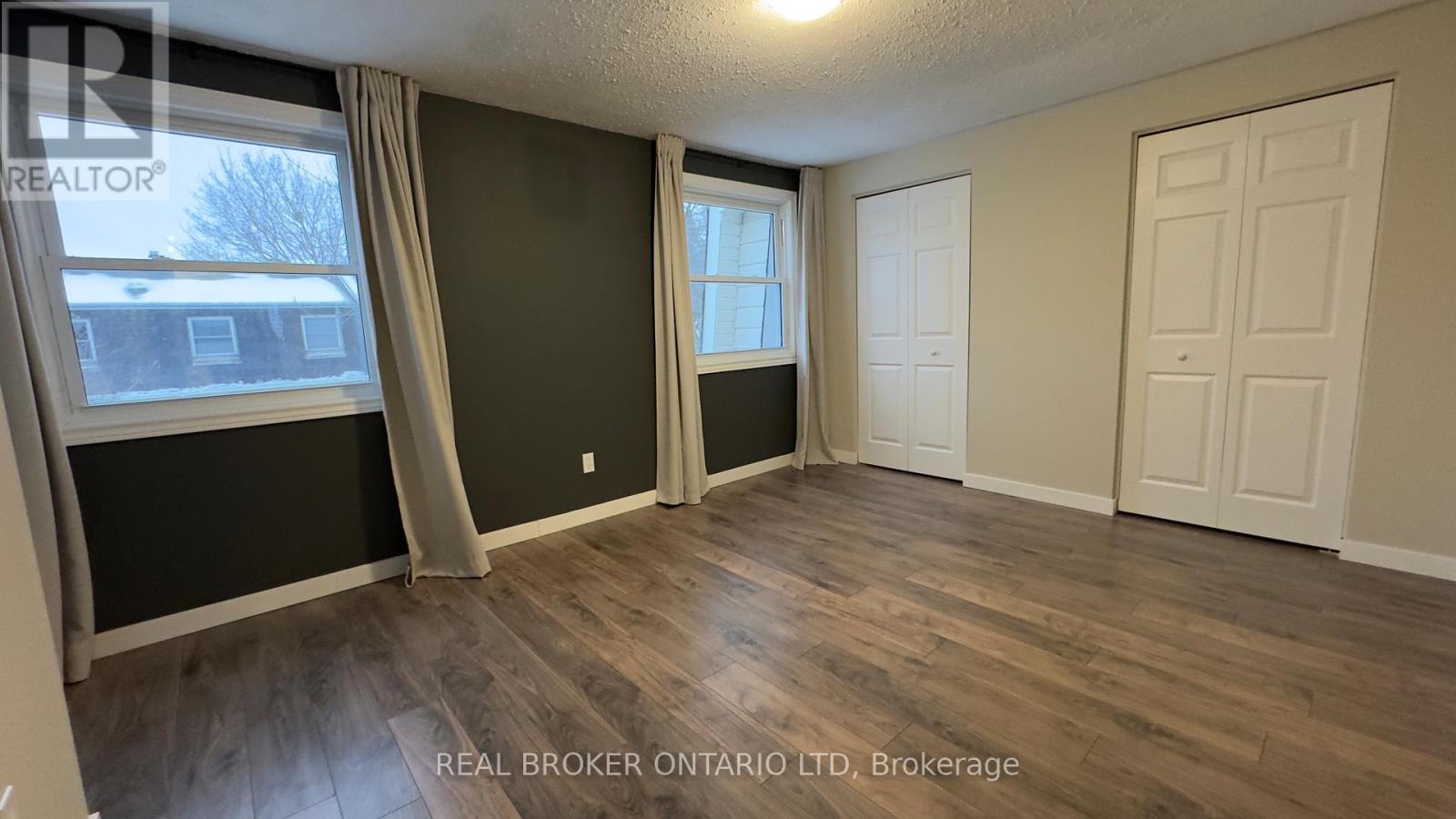 A room with a window and a door is shown in this image.