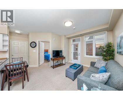 A living room with a grey couch and a wooden chair.