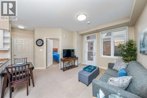 A living room with a grey couch and a wooden chair.