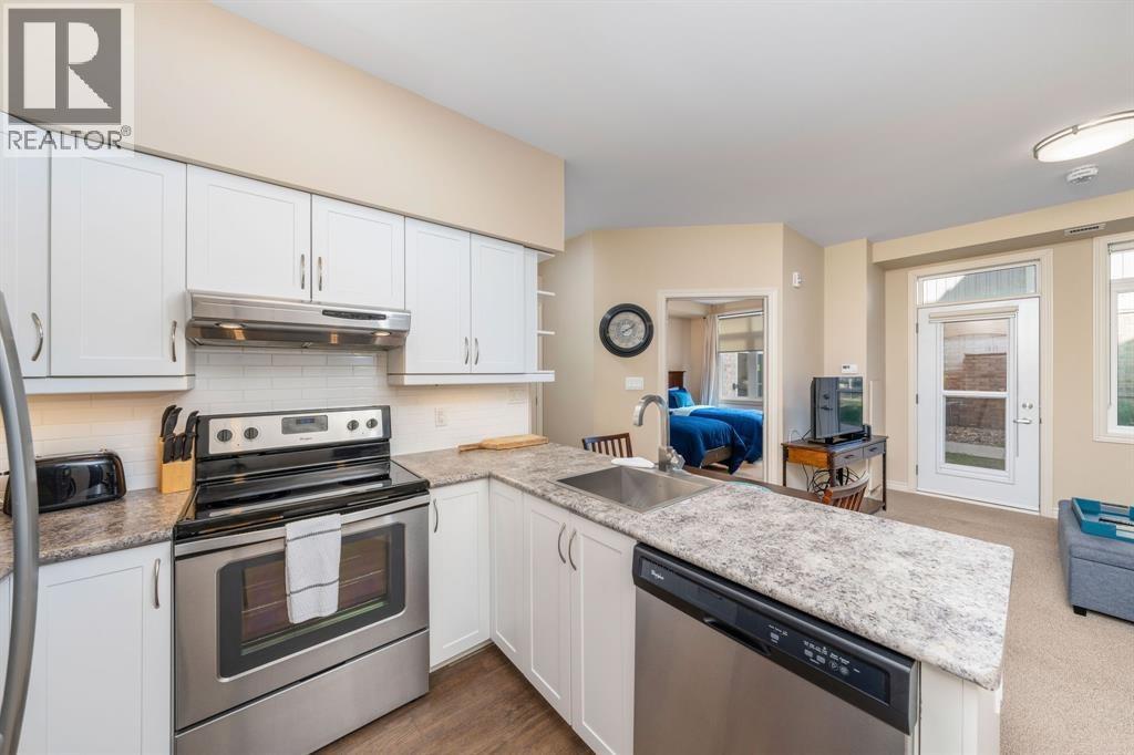 A kitchen with white cabinets and a granite countertop.