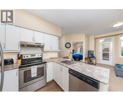 A kitchen with white cabinets and a granite countertop.