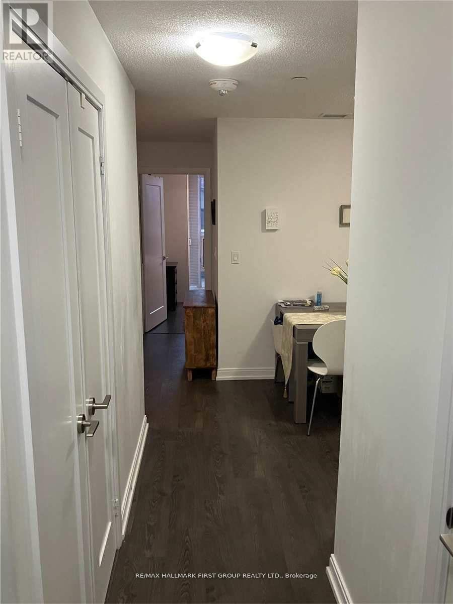 A hallway with a table and chairs at the end.