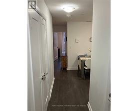 A hallway with a table and chairs at the end.