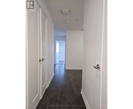 A hallway with a table and chairs at the end.