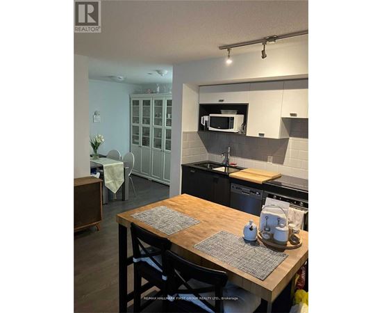 A kitchen with a wooden table and chairs.