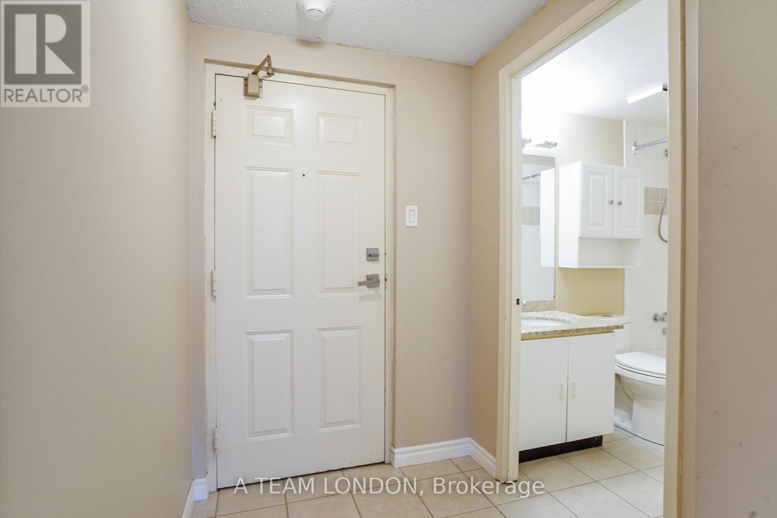 A white door with a gold handle is in a room with a white ceiling.