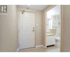A white door with a gold handle is in a room with a white ceiling.