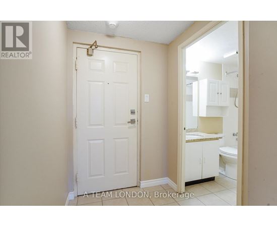 A white door with a gold handle is in a room with a white ceiling.