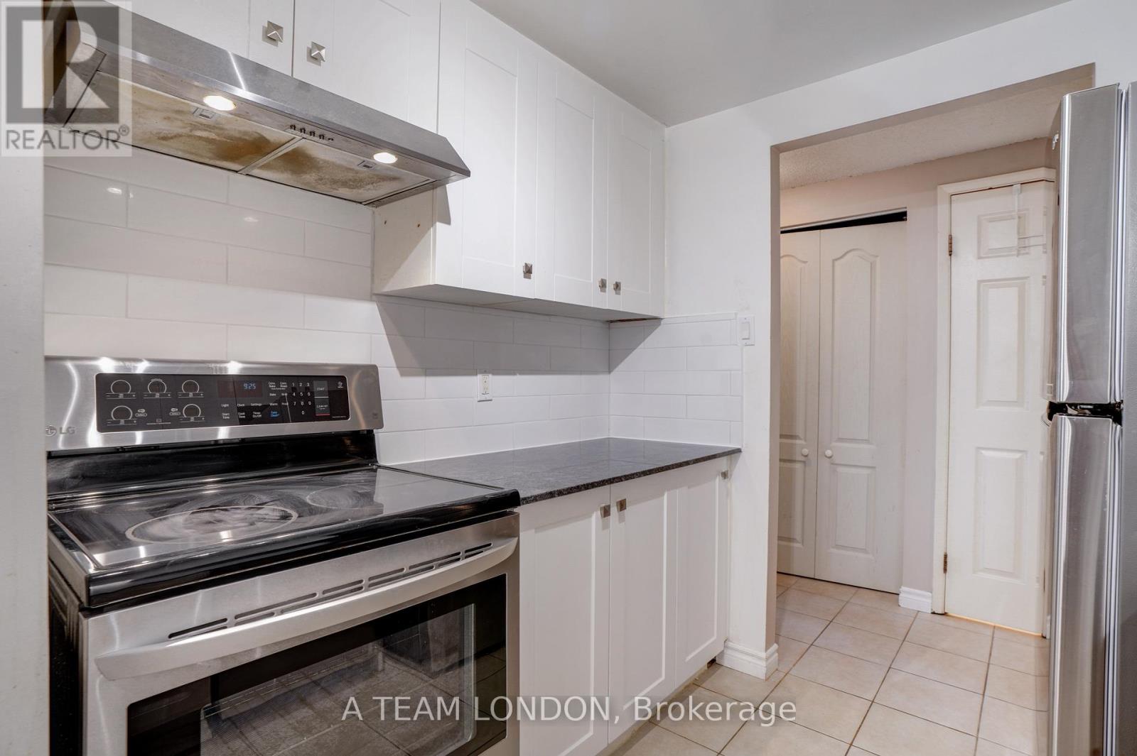 A kitchen with a stove top oven and a refrigerator.