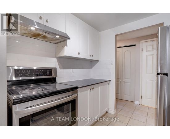 A kitchen with a stove top oven and a refrigerator.